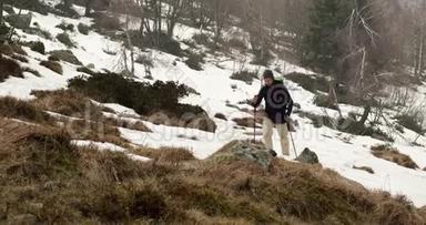 徒步旅行者背着背包走在雪地小径上。 在后面。 真正的背包客，成人徒步旅行或徒步旅行