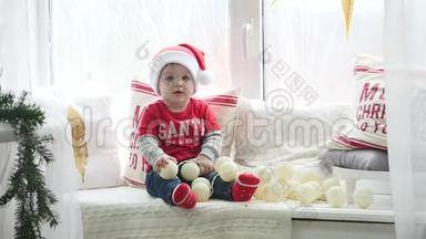 美丽的小宝宝庆祝圣诞节.. 新年`假期。 穿着圣诞服装带礼物的孩子。 圣诞老人