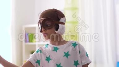 戴着飞行员帽子的男孩在家玩飞机玩具