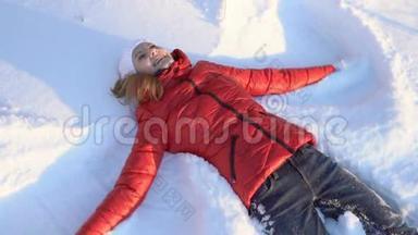迷人的年轻女子在<strong>冬季</strong>公园里做<strong>雪天</strong>使，玩得很开心，微笑着。慢动作。