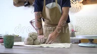 波特在轻型陶工的工作空间里揉一块粘土