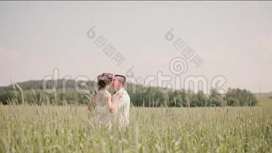 在夏天的婚礼上，一对美丽的恋人站在麦田里。 新郎新娘拥抱亲吻