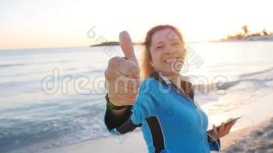 在海滩上竖起大拇指的年轻女子手牌