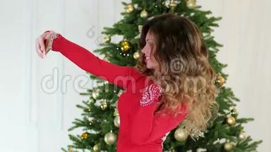 圣诞派对，新年自拍的女孩，在圣诞树的背景上拍照，这是一个美丽的圣诞树