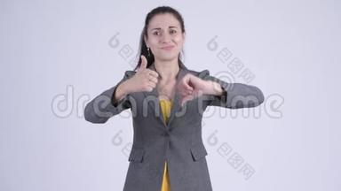 困惑的年轻女商人在竖起大拇指和竖起大拇指之间做出选择