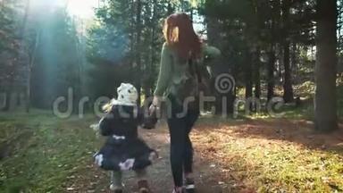 幸福的母女正沿着森林路走着.. 母女走在秋林中.. 吐出来