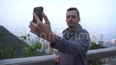 香港的年轻人用智能手机自拍。 游客正在享受观光和自画像