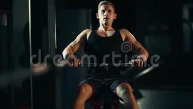肌肉发达的人在黑暗的健身房锻炼背部肌肉，举重