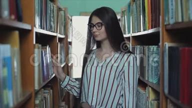 漂亮的<strong>小</strong>女孩留着长长的黑发在图书馆的<strong>书架</strong>之间。