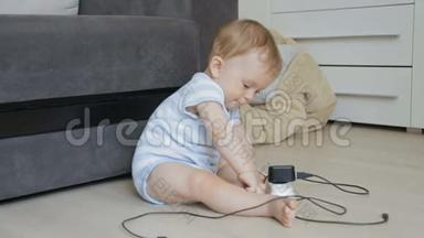 婴儿独自坐在房间里，玩插座和充电线的概念，婴儿在危险中。 幼儿玩电线和CA