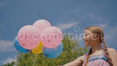 年轻女孩带着鲜艳的彩色球，微笑着，在相机上摆姿势。 情绪良好，积极向上..