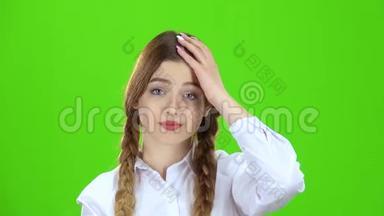 穿着白色衬衫和辫子的女孩露<strong>出拳</strong>头。 绿色屏幕