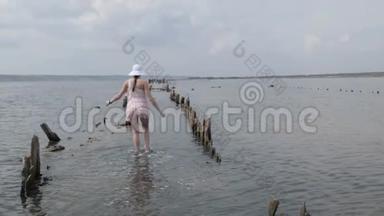 穿着漂亮裙子的<strong>旅游</strong>妇女在水中漫步到地平线上。 <strong>日</strong>落<strong>旅游</strong>体验，女孩享受轻松
