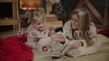 圣诞快乐，新年快乐。美丽的家庭在圣诞节的内部。年轻漂亮的母亲给她读书