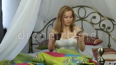 快乐的女人坐在床上跳舞唱<strong>歌</strong>，喝咖啡，和朋友在电话里聊天。 4K