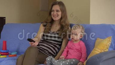 妈妈<strong>拿</strong>着<strong>遥控</strong>器，女儿坐在沙发上看电视。
