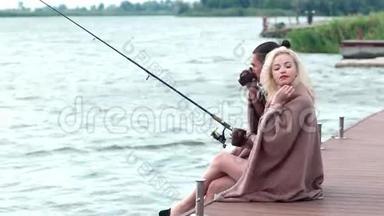 一对美丽的情侣在湖边钓鱼，一个男人坐在码头上，一对<strong>恋人</strong>，一对<strong>恋人</strong>坐在一起