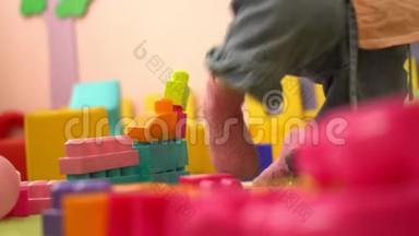 学龄前可爱的幼儿在幼儿园玩多种颜色的积木