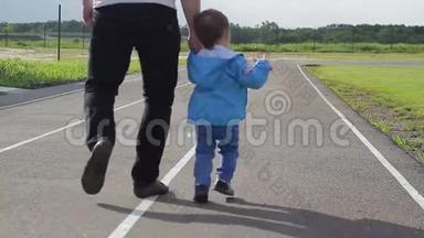 小男孩和爸爸在跑步机体育场跑步