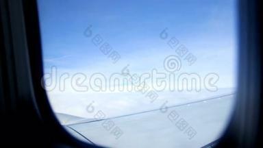 从飞机窗口观看。 可以看到飞机的天空、云层和机翼。 天气晴朗，天气晴朗