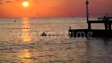 海上美丽的日落。 从码头<strong>跳入</strong>地中海的家伙的剪影
