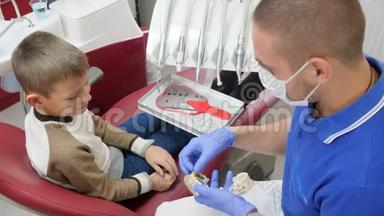 男医生戴着医用口罩，在儿童牙椅上展示牙板模型