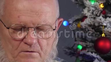 快乐的老人在花环上的圣诞树背景上用梳子梳理他的灰色胡须，绿色的<strong>UFO</strong>球，质子紫色玩具