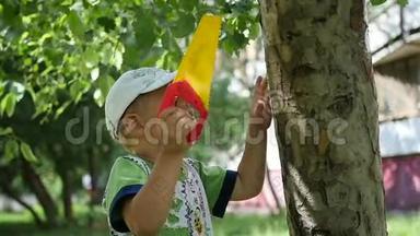 一个孩子站在一棵树附近的公园里。 户外运动会