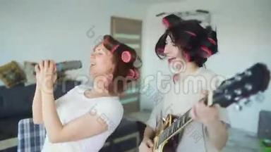 两个有趣的女孩用梳子<strong>唱歌</strong>，弹电吉他<strong>跳舞</strong>，在家<strong>唱歌</strong>，玩得开心