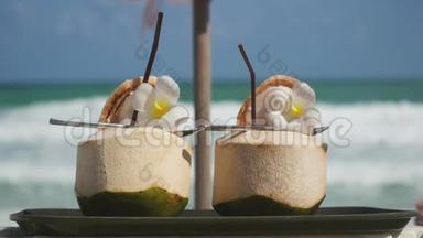 热带新鲜椰子鸡尾<strong>酒</strong>在海滩咖啡馆装饰梅花，有绿松石海背景。 3840x2160