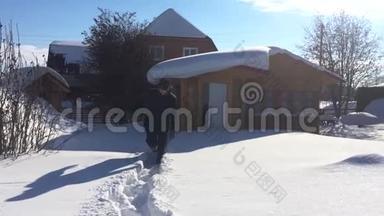 一个人穿过大雪漂流在大自然上，在白雪覆盖的房子背景下<strong>跳入</strong>雪中。 高清高清