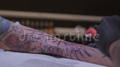 纹身师在工作室做纹身，特写专业纹身师在一个年轻女孩的手上做纹身`