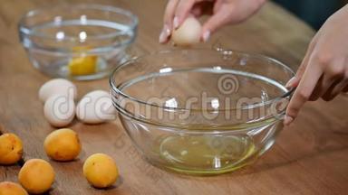 女人的手把鸡蛋打碎，把蛋清、蛋黄和鸡蛋壳分开