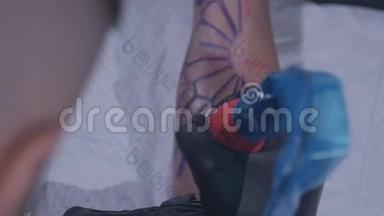 纹身师在工作室做纹身，特写专业纹身师用慢手在一个年轻女孩`做纹身