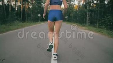 把慢<strong>跑鞋</strong>和慢跑者的腿收起来。 一名女运动员在公园路外训练的背面。