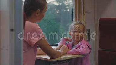 一家人在亚洲的火车旅行中消磨时间，寻找窗口，交谈