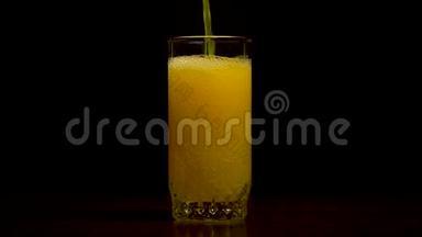 橙色苏打水大玻璃，溢出的橙色苏打水特写与气泡隔离在黑色背景。 橙色汽水