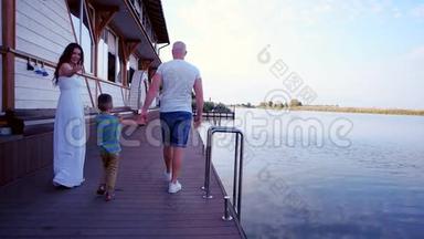 幸福的一家人在船上，父母带着一个孩子在河上避暑，爸爸妈妈和他的儿子一起度过时光