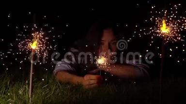 一个在草地上燃烧着火花的女人。 <strong>500</strong>fps超慢动作视频拍摄