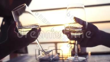 两个人手拿酒杯，手拿酒，背景是夕阳和大海。 高清，1920x1080。 慢动作