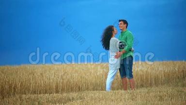 年轻夫妇在田野里接吻。 年轻女子在麦田里拥抱一个白种人，亲吻每一个人
