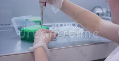女医学家用吸管在实验室做研究。 研究概念。 戴着蓝色手套