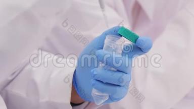 <strong>生物技术专家</strong>从玻璃瓶中抽取一个液体样品进行检验
