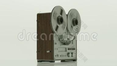 旧卷筒录音机与旋转卷筒在白色背景。 在磁带机上<strong>滚动</strong>磁带<strong>播放</strong>，慢动作。