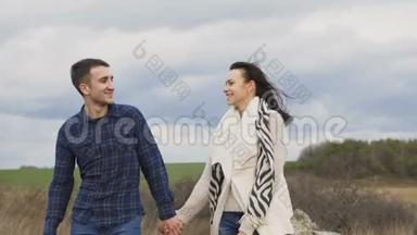 可爱的一对夫妇在风天走在岩石上。 4K