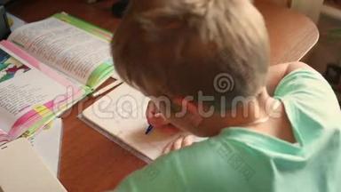 孩子做家庭作业，在桌上写一本书