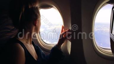 女孩<strong>坐飞机</strong>飞行，欣赏舷窗的风景并关闭它。