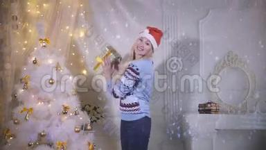 美丽的女孩微笑着来到相机，在圣诞树附近跳舞。 新年，除夕，圣诞节的概念。