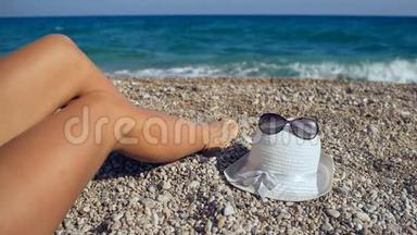 在靠近海边的海滩上欣赏美女的双腿，在夏季周末放松，享受美好的一天和阳光