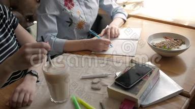 学生们漂亮的女孩早餐在咖啡馆里做作业，写婴儿床，喝咖啡